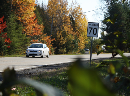 Voiture sur le Chemin Joliette près d'une affiche de vitesse